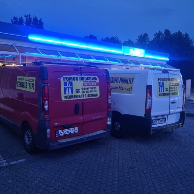 Dwa firmowe samochody osobowe zaparkowane obok siebie.